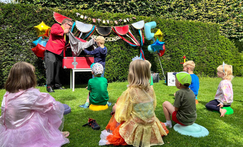 Kinderzauberer Sascha Lange bei einer Gartenparty mit Kindern
