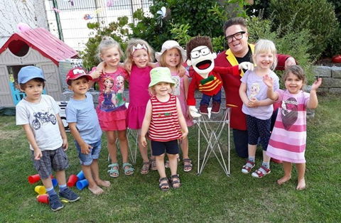 Sascha Lange und Flitzikus mit einer Kindergruppe im Garten